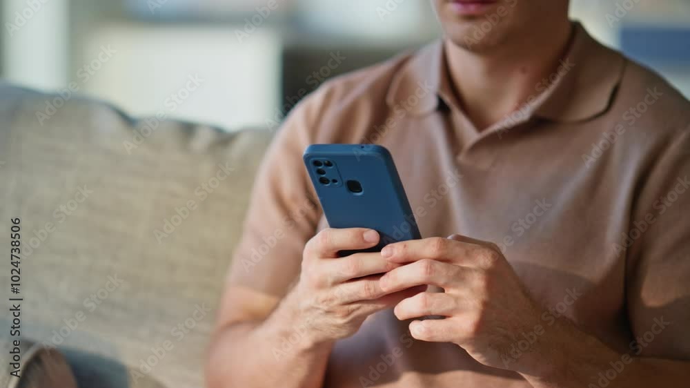 Guy hands holding mobile phone at comfortable couch at domestic weekend closeup. Guy hands holding mobile phone at comfortable couch at domestic weekend closeup.