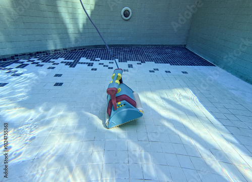 Wired automatic submersible vacuum cleaning robot that sweeps the floor and walls of the pool in the water. photo