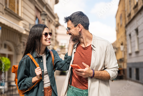 Beautiful young alternative hipster tourists couple in love walking outdoors at the city street, hugging, wearing modern cool attitude wardrobe. Fashionable and stylish people man and woman enjoy life