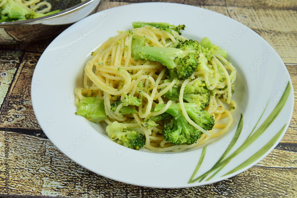Eating hot spaghetti with broccoli and parmesan cheese in a plate Eating hot spaghetti with broccoli and parmesan cheese in a plate