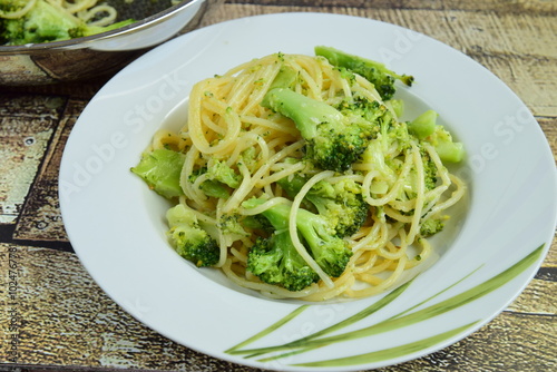 Eating hot spaghetti with broccoli and parmesan cheese in a plate