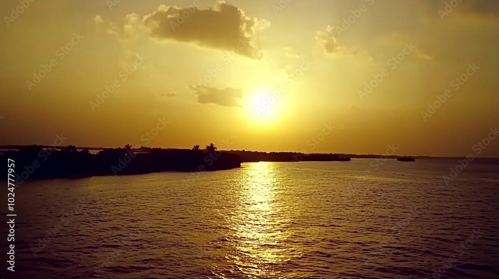 Naklejka premium A breathtaking golden sunset over a calm, reflecting river, with a silhouette of trees and a bridge in the distance.