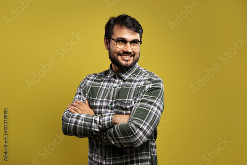 man in glasses with arms crossed, smiling and looking up