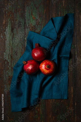 Obraz na płótnie Ripe pomegranates on a turquoise linen napkin on a wooden table w salonie