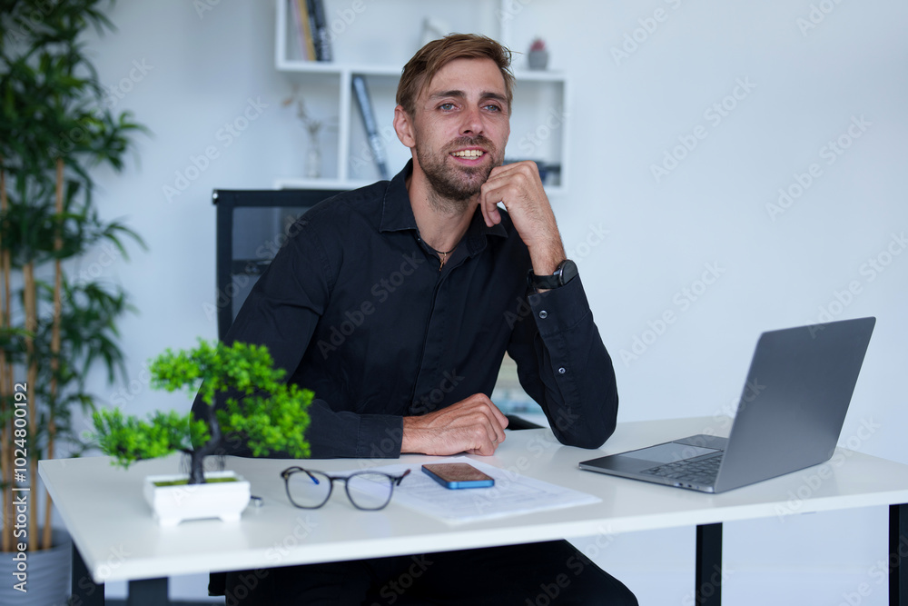 Man with sunglasses works in office with computer. Businessman is working on business ideas in light office in business center. Concept people in a office job.