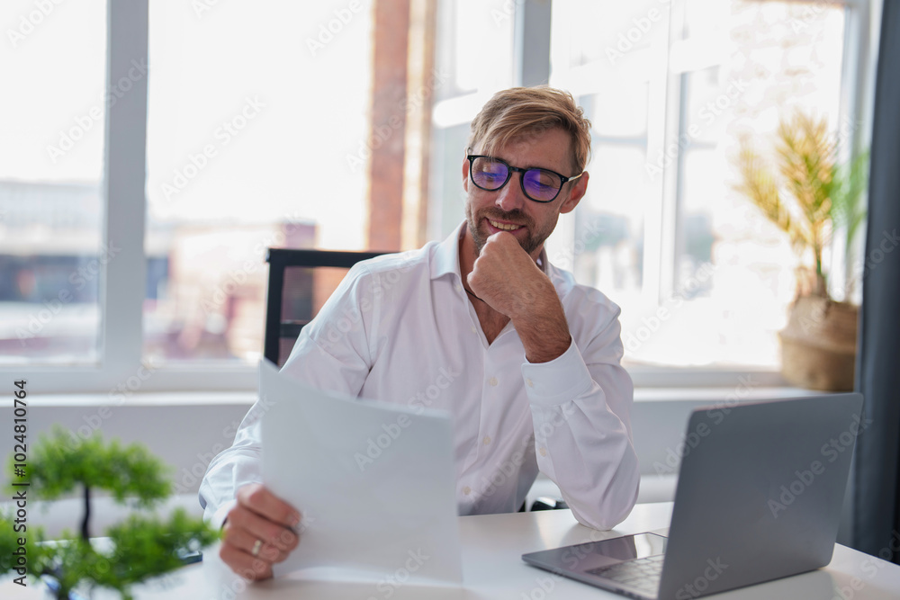 Man with sunglasses works in office with computer. Businessman is working on business ideas in light office in business center. Concept people in a office job.