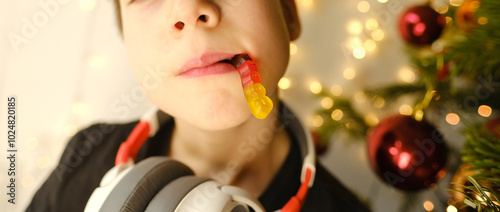 Фотография Joyful child, boy aged 10-12 with gelatin worm sweet, celebrate Christmas by pla