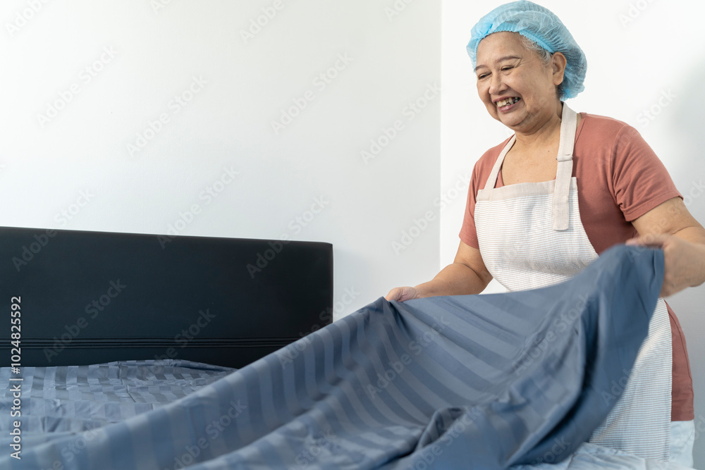 Cheerful Housekeeper is making the bed in house or apartment Cheerful Housekeeper is making the bed in house or apartment