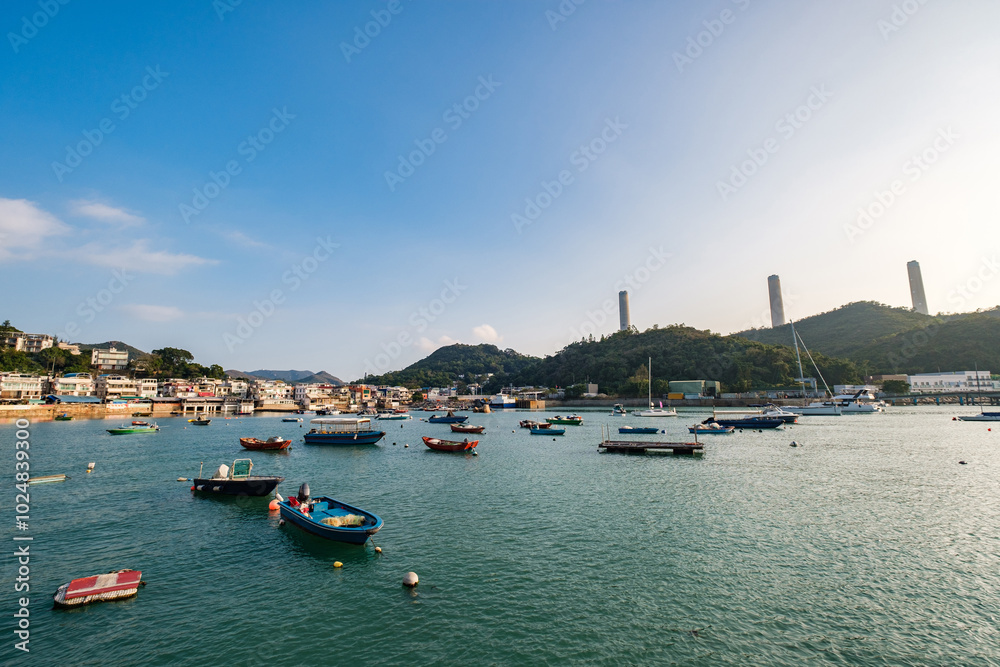 Fototapeta premium A row of traditional buildings in fishing village at Yung Shue Wan in Lamma Island, with boats in the foreground