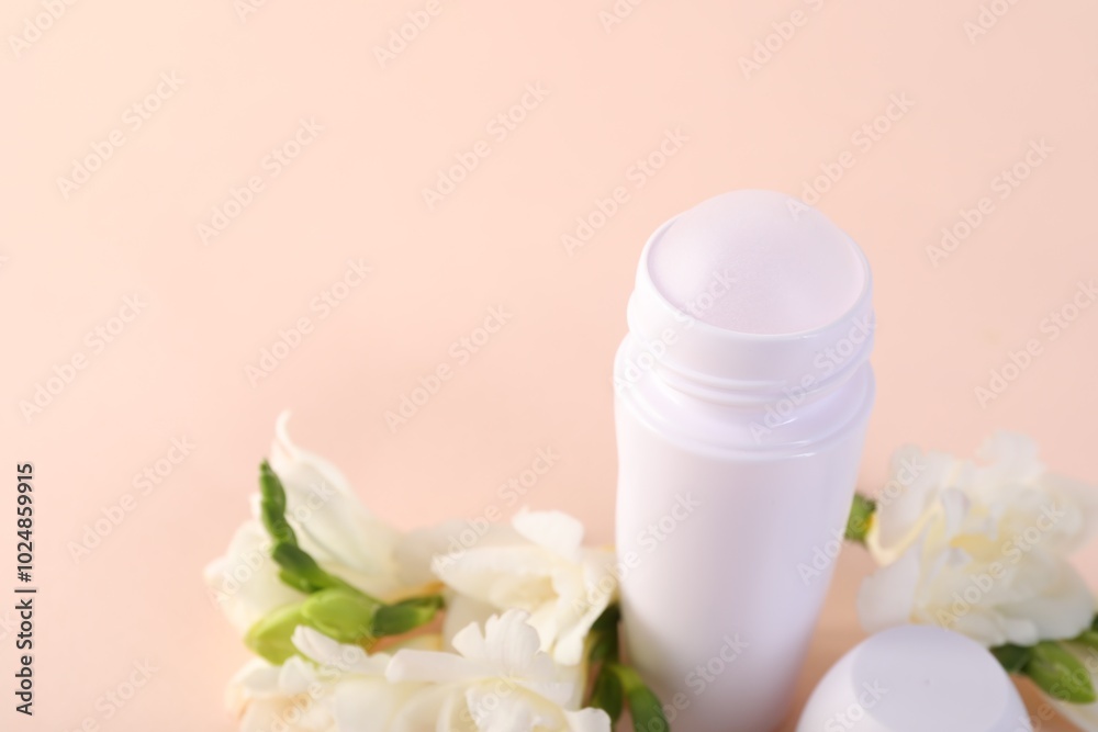 Roll-on deodorant and beautiful eustoma flowers on beige background, closeup Roll-on deodorant and beautiful eustoma flowers on beige background, closeup