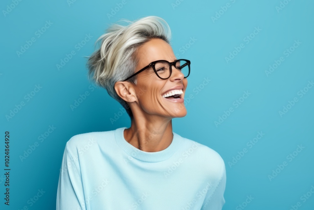 smiling middle aged woman in eyeglasses looking up on blue background smiling middle aged woman in eyeglasses looking up on blue background