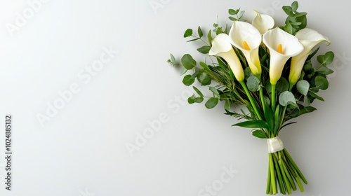 Elegant calla lily bouquet with green eucalyptus leaves on a soft gray background, perfect for weddings and special occasions. photo