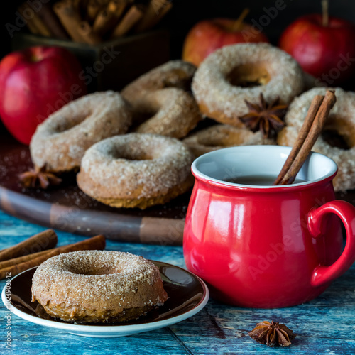 A sugar cinnamon coated doughnut with hot apple cider, ready for eating.