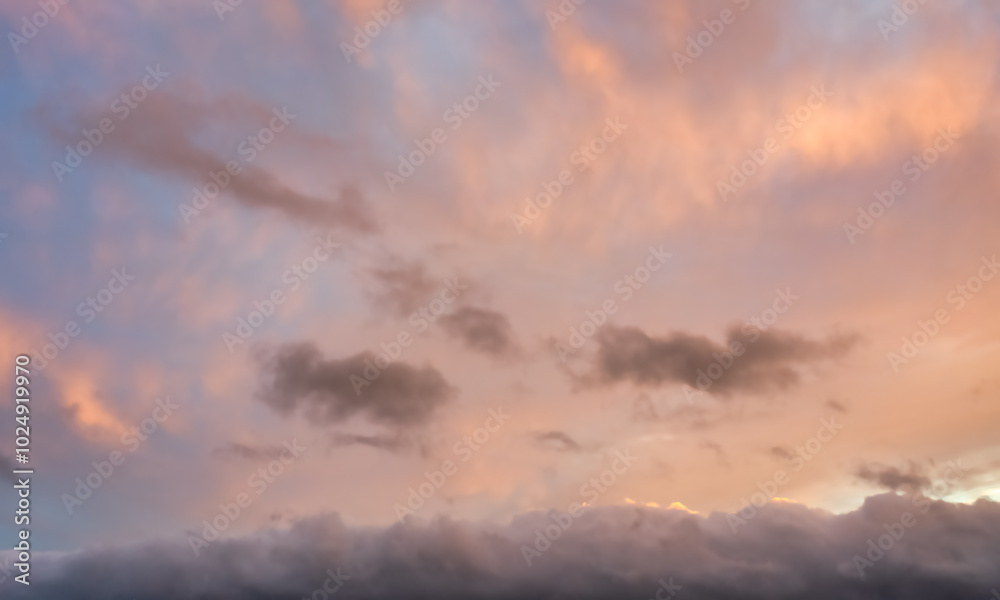 Fototapeta premium A beautiful sky tinted by the sun leaving vibrant shades of gold, pink, blue and multicolored. Clouds in the twilight evening and morning sky. Cloudy sky background in the evening, and during the day.