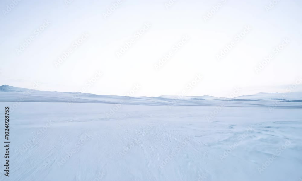 Peaceful snowy landscape with low mountain range under blue sky. Peaceful snowy landscape with low mountain range under blue sky.