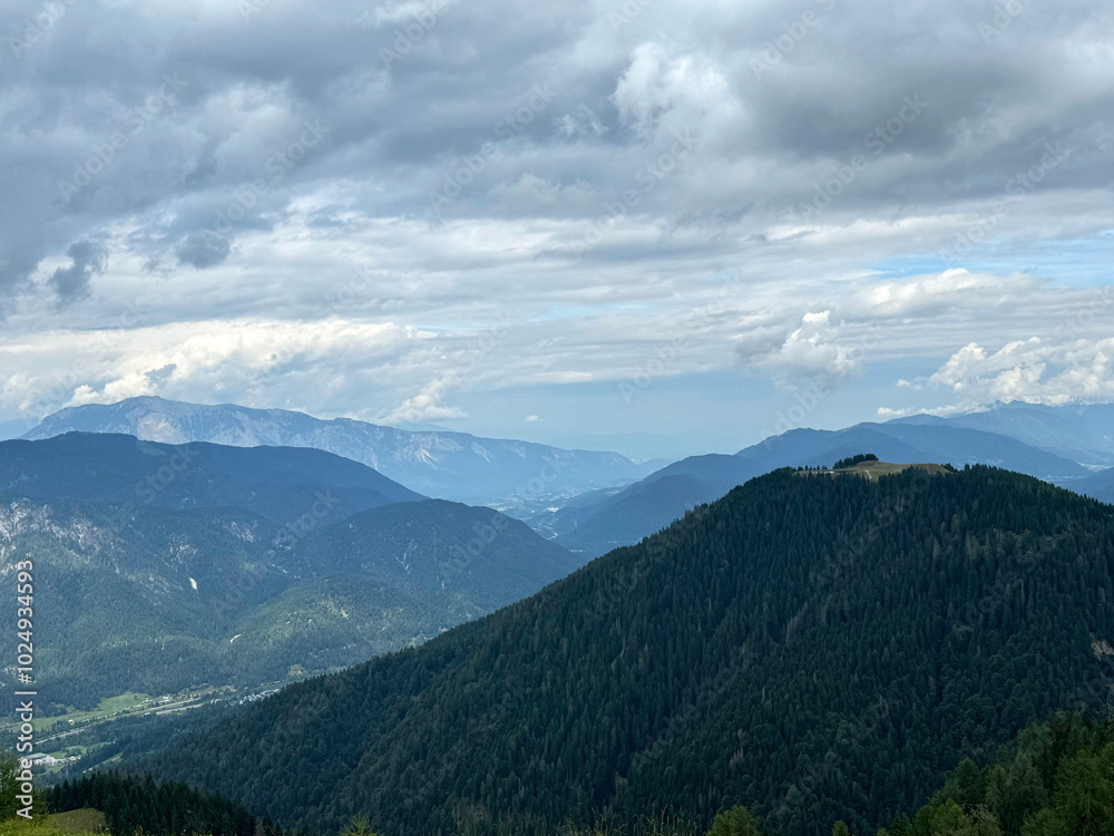 Scenic mountain landscape with lush green forests and majestic cloudy sky Scenic mountain landscape with lush green forests and majestic cloudy sky
