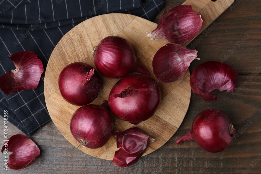 Fresh onions with peels on wooden table, flat lay Fresh onions with peels on wooden table, flat lay