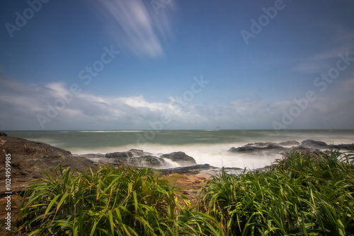 Beach, with lava rocks and vegetation, view of the sea in the evening at sunset. Landscape with clouds in Induruwa, Bentota Beach, Sri Lanka, India, Asia photo