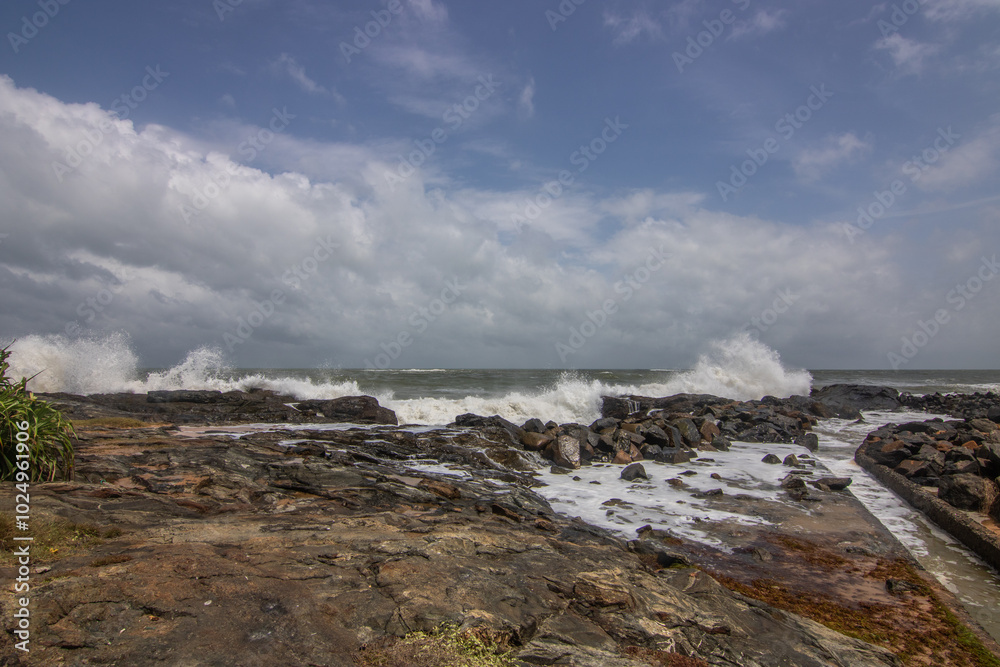 Beach, with lava rocks and vegetation, view of the sea in the evening at sunset. Landscape with clouds in Induruwa, Bentota Beach, Sri Lanka, India, Asia Beach, with lava rocks and vegetation, view of the sea in the evening at sunset. Landscape with clouds in Induruwa, Bentota Beach, Sri Lanka, India, Asia