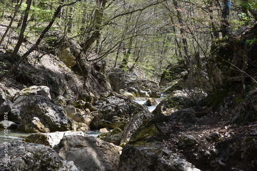 A pile of fragments of rock in the bed of a mountain river with crystal clear water in the mountains of Crimea