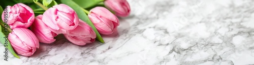 A bouquet of pink tulips on a marble surface, conveying beauty and freshness.