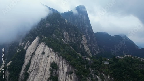 Huashan, China: Aerial drone footage of the dramatic Mt Huashan near Xi'an in Shaanxi in central China with atmospheric mist and fog. 