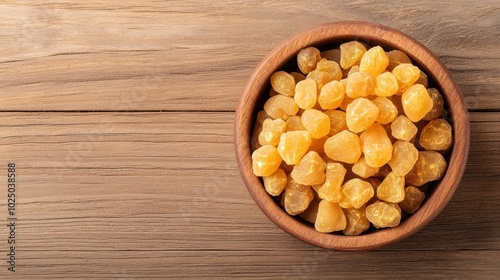 Bowl of yellow resin pieces on a wooden surface, natural and organic ingredients.