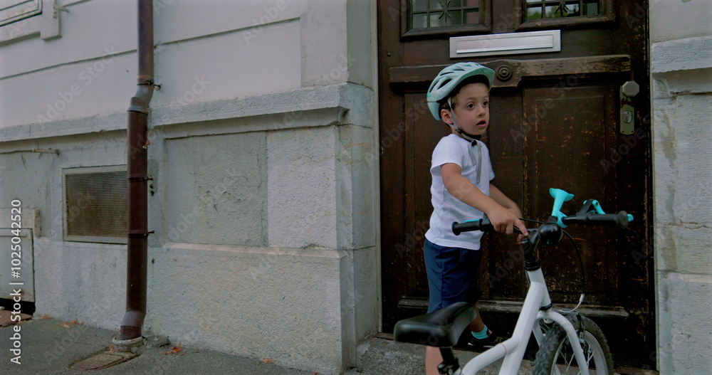 Boy securing his bicycle outside a building, wearing a helmet, showcasing responsible and independent outdoor activities for children, emphasizing safety and exploration in an urban environment
