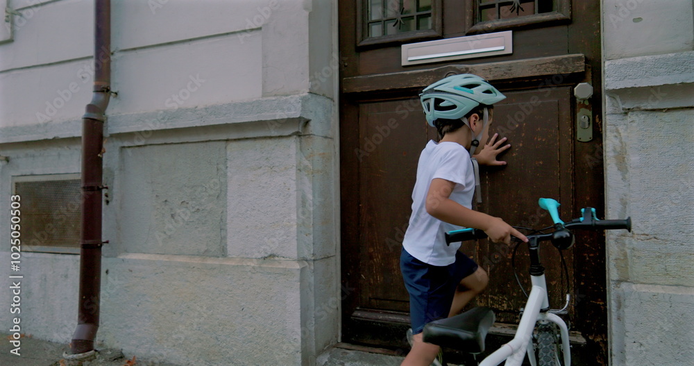 Boy securing his bicycle outside a building, wearing a helmet, showcasing responsible and independent outdoor activities for children, emphasizing safety and exploration in an urban environment Boy securing his bicycle outside a building, wearing a helmet, showcasing responsible and independent outdoor activities for children, emphasizing safety and exploration in an urban environment