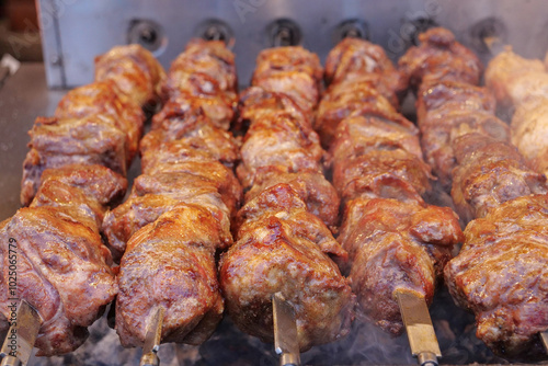 Kebabs on skewers are grilled on hot coals photo