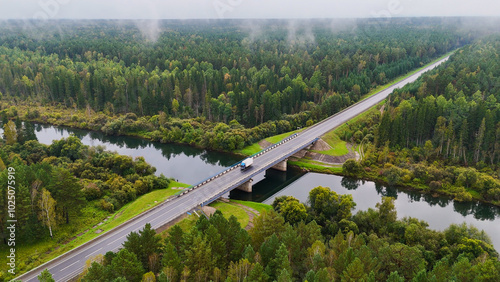 A truck and cars are driving along a beautiful road