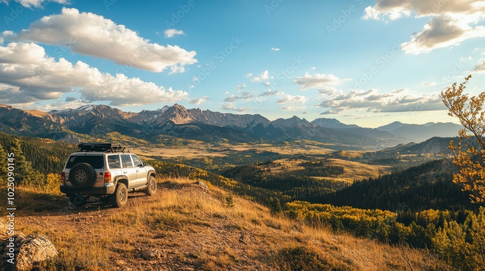 A Silver SUV Parked on a Mountain Overlooking an Autumnal Valley A Silver SUV Parked on a Mountain Overlooking an Autumnal Valley