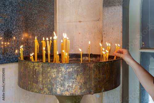 Hand lighting candles in a prayer offering