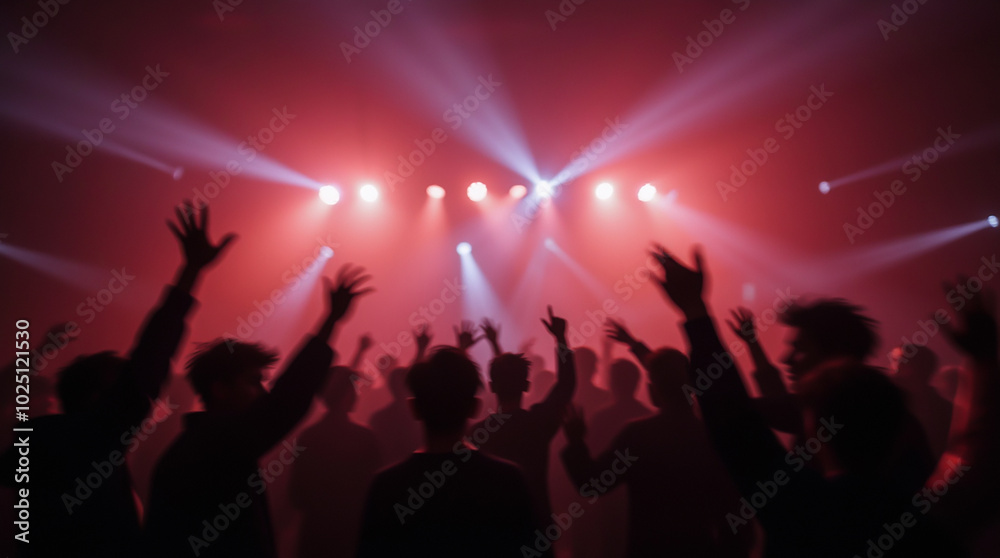 The image conveys the atmosphere of a concert with bright lighting and silhouettes of the audience The image conveys the atmosphere of a concert with bright lighting and silhouettes of the audience