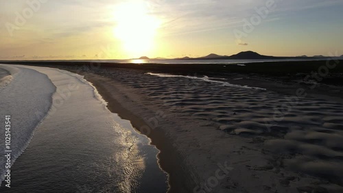 Wallpaper Mural Aerial drone footage of an ocean beach and white sand dunes with mountains in the background at sunset Torontodigital.ca