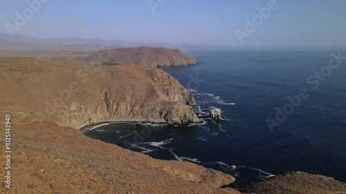 Wallpaper Mural Aerial drone footage of a steep and rocky desert coastline with cliffs and crashing waves on a clear summer day Torontodigital.ca