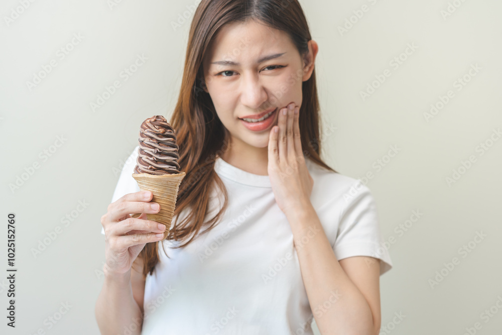 Face expression suffering from sensitive teeth and cold, asian young woman, girl hand touching cheek, hurt or pain eating ice cream. Toothache molar tooth, dental problem isolated on white background. Face expression suffering from sensitive teeth and cold, asian young woman, girl hand touching cheek, hurt or pain eating ice cream. Toothache molar tooth, dental problem isolated on white background.