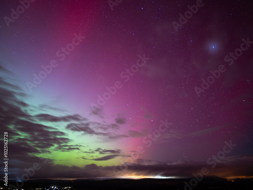 Northern lights in Saxony, Germany on the 11. October 2024. Beautiful colors ranging from green to magenta and red in the night sky. Light rays of the aurora borealis are visible in Europe. photo