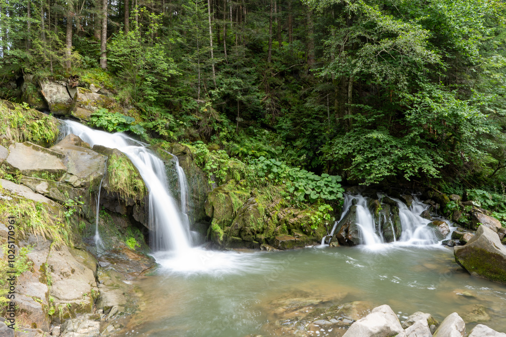 Mountain waterfall in the forest. Green nature. Lake water Kamianka in the Ukrainian Carpathians river Mountain waterfall in the forest. Green nature. Lake water Kamianka in the Ukrainian Carpathians river