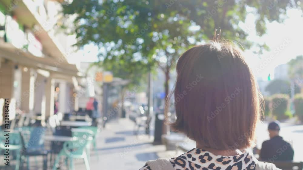 woman walking with a backpack around the city. walk around the city. a young cheerful woman in a leopard print blouse and with a backpack walks down the street on a summer day. woman walking with a backpack around the city. walk around the city. a young cheerful woman in a leopard print blouse and with a backpack walks down the street on a summer day.