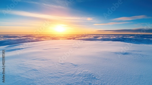 A breathtaking sunrise unfolds over a snowy mountain, casting golden hues across the landscape as clouds linger beneath. The scene captures the tranquil beauty of dawn in a serene atmosphere