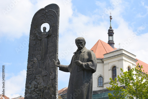 LVIV, UKRAINE - JULY 27, 2020: statue of Taras Shevchenko- famous ukrainian poet, artist,  with a 12-meter decorative stele with reliefs located on prospect Svobody in Lviv photo