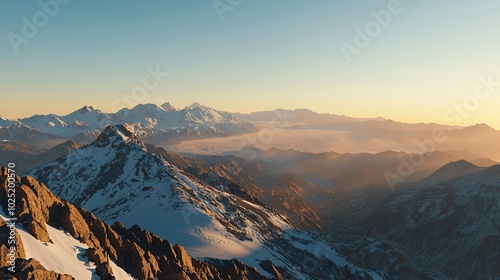   A view of the mountain's peak with ample snow in the foreground and sunlight illuminating the top