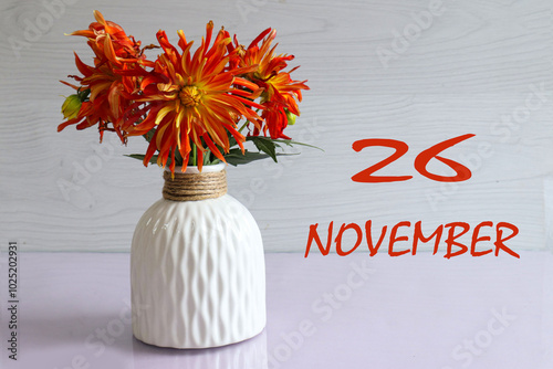 Calendar for November 26: numbers 26, name of the month November, bouquet of yellow dahlias on a light background