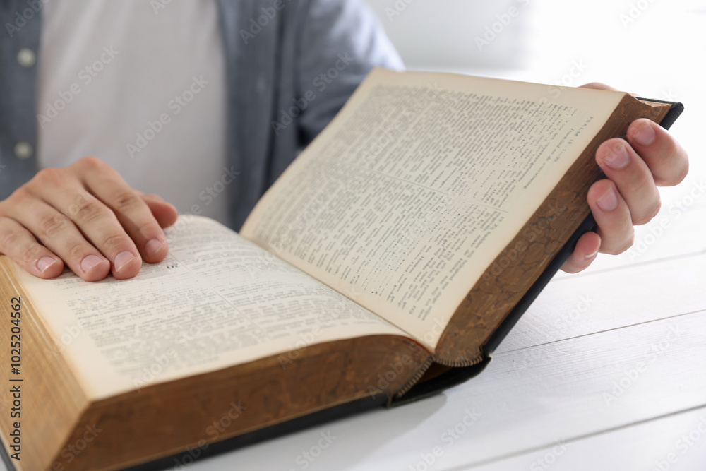Man with Bible at white wooden table, closeup Man with Bible at white wooden table, closeup
