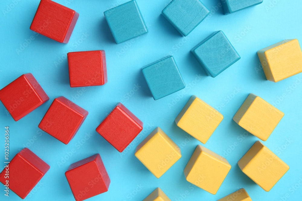 Many colorful cubes on light blue background, flat lay Many colorful cubes on light blue background, flat lay