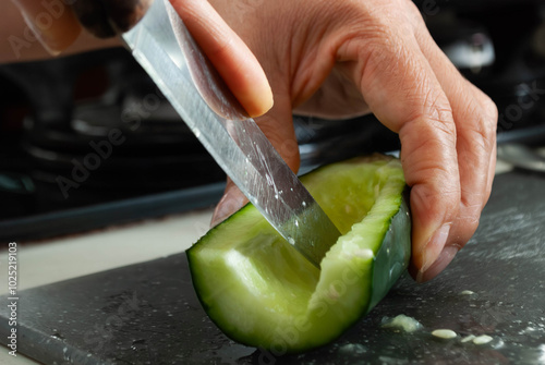 Close-up of a woman's hands cutting vegetables with a knife on a cutting board. Home cooking concept, gastronomy, veganism.