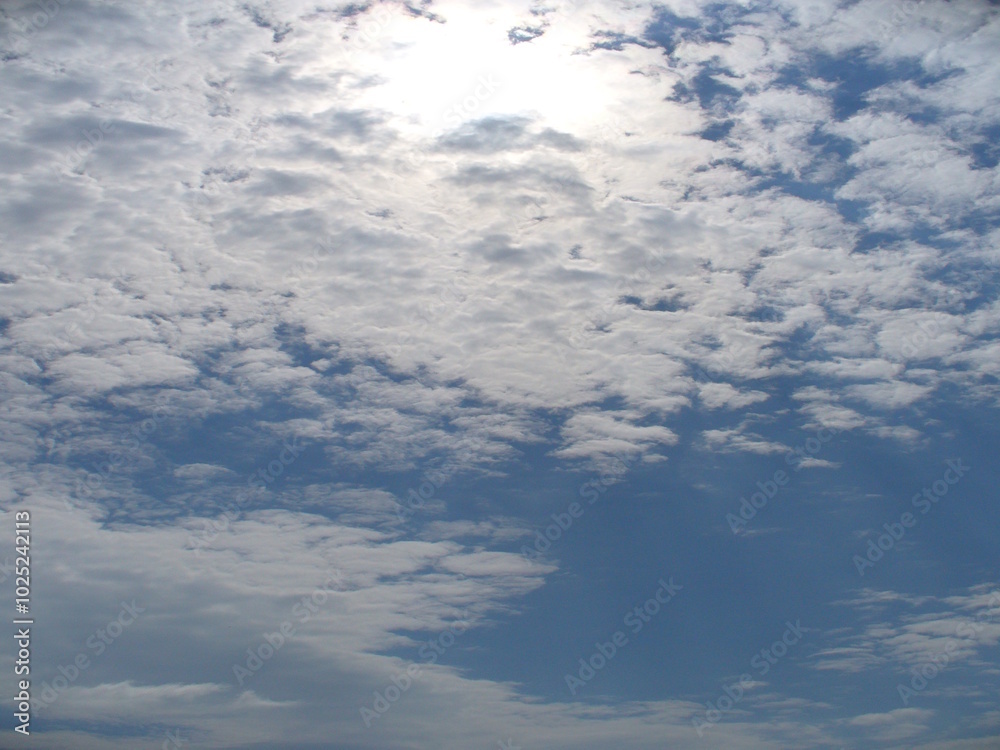 Blue sky with white and gray clouds and sulight - natural background. Topics: weather, meteorology, atmosphere, sky space, season Blue sky with white and gray clouds and sulight - natural background. Topics: weather, meteorology, atmosphere, sky space, season