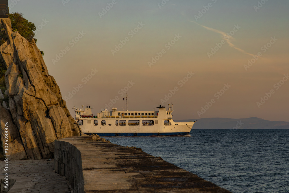 Obraz premium Sunrise ferry with passengers enters the port of Trpanj