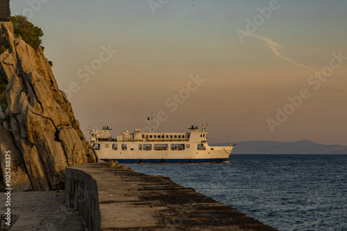 Sunrise ferry with passengers enters the port of Trpanj photo